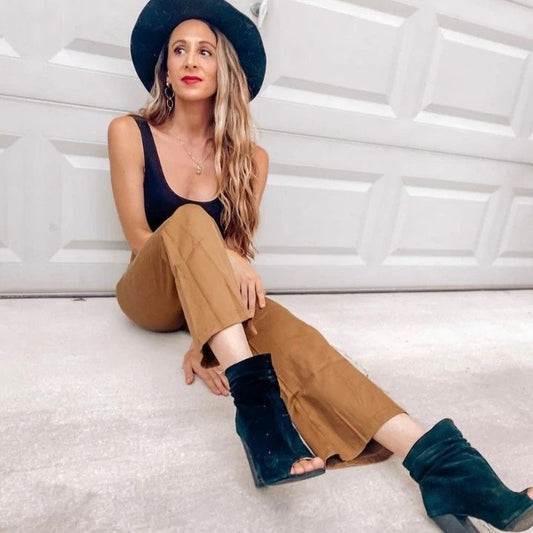 Woman wearing brown pants and wide brim hat.