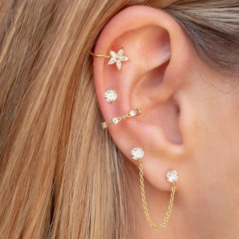 A model wearing multiple stud chain earrings.