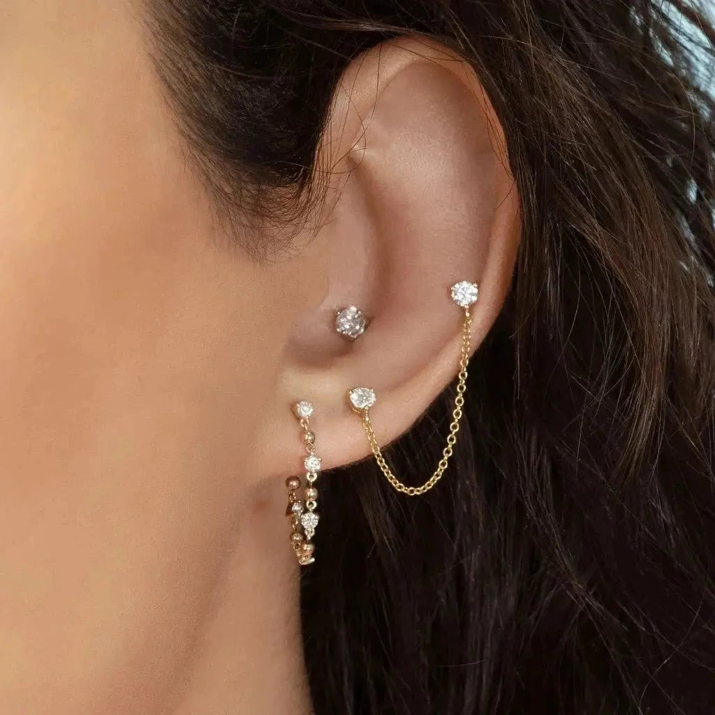 A model wearing multiple ear piercings.