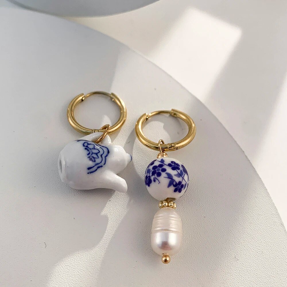 Closeup of the blue and white ceramic tea kettle earrings.
