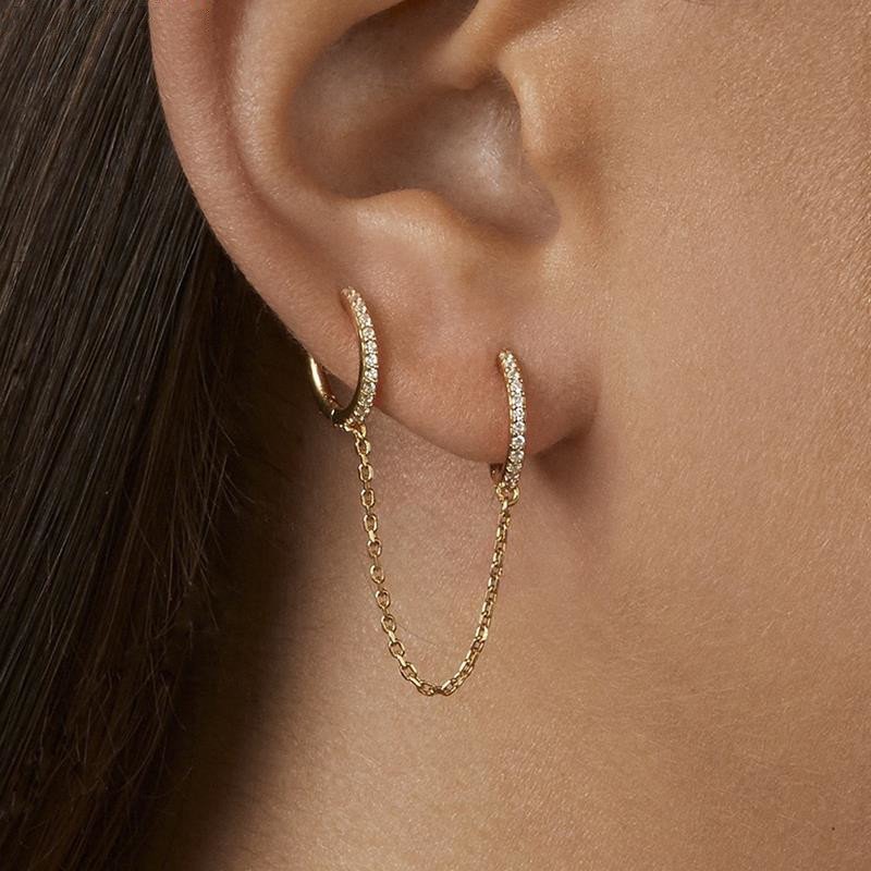 A model wearing the Double Huggie CZ Chain Earring.