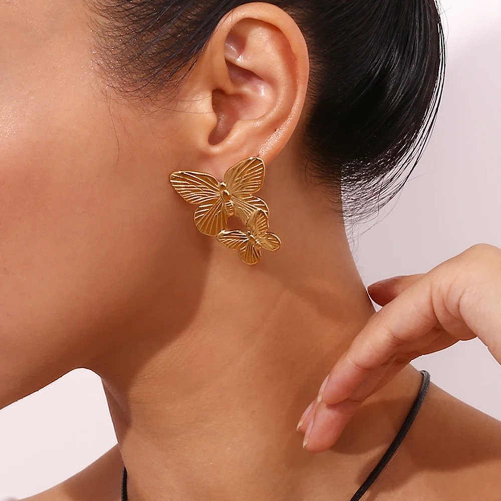 A model wearing the Large Gold Butterfly Earrings.