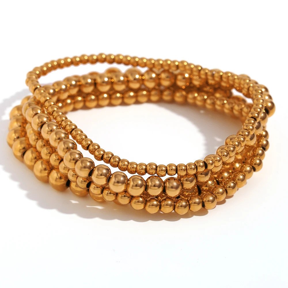 Gold beaded bracelet stack.