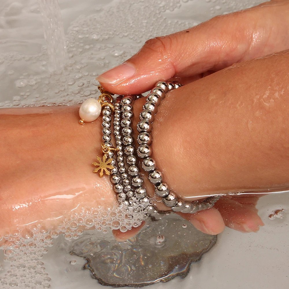 A woman wearing silver beaded bracelets.