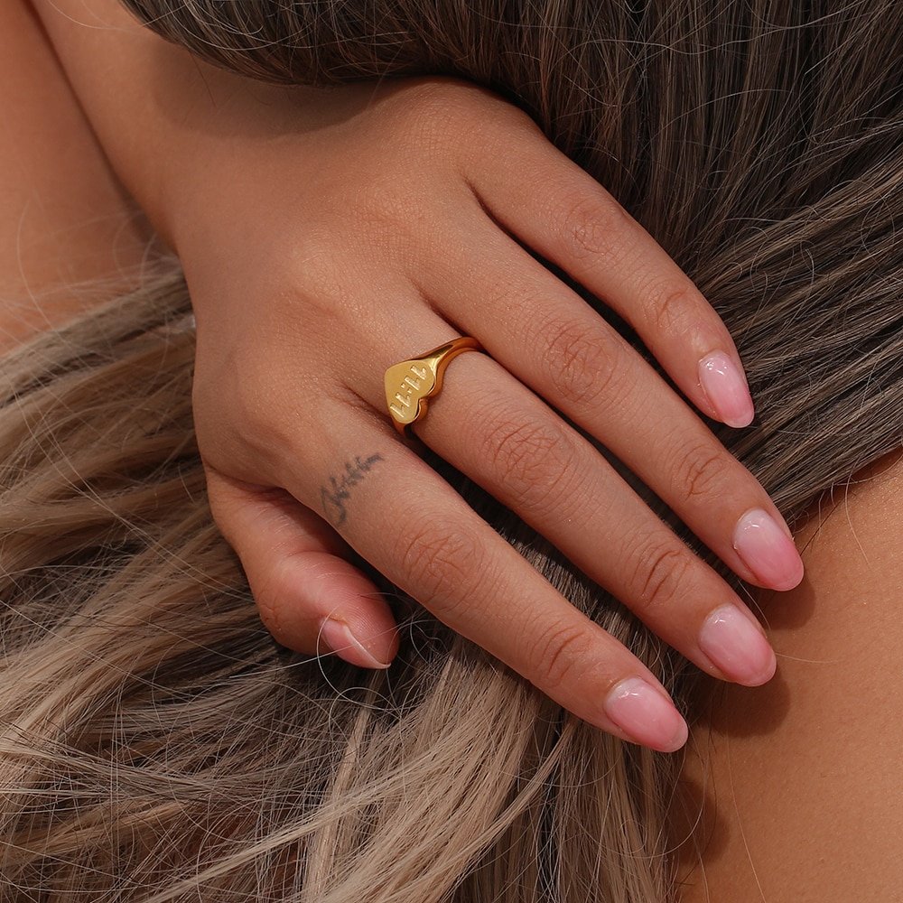 A woman wearing the 11:11 Gold Heart Ring.