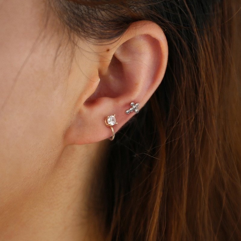 Beaded Cross Studs being modeled on a woman's ear.