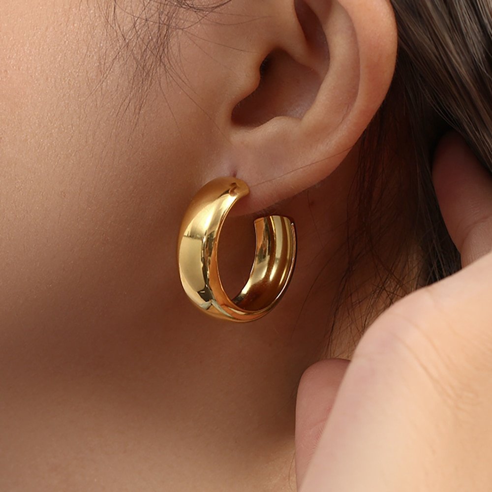 A woman wearing the Bianca Gold Hoop Earrings.