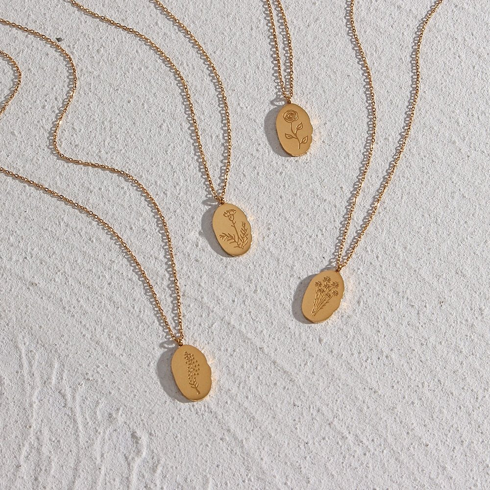 Four gold necklaces with flower pendants.