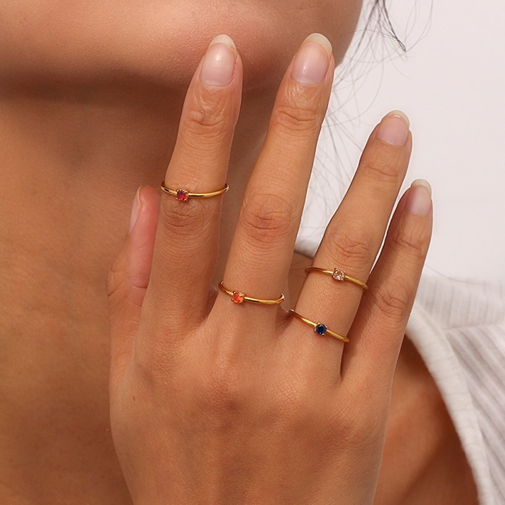 A model wearing multiple birthstone rings.