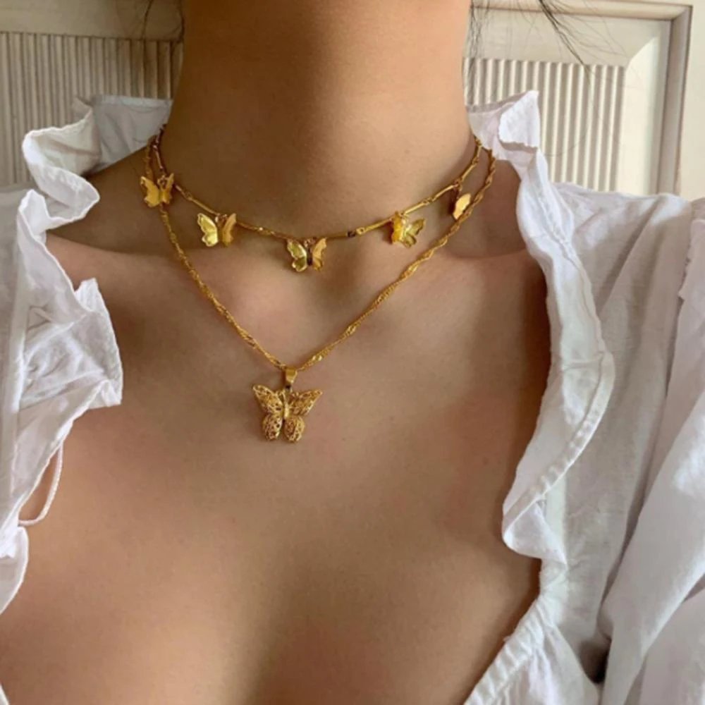 A woman wearing multiple gold butterfly necklaces.