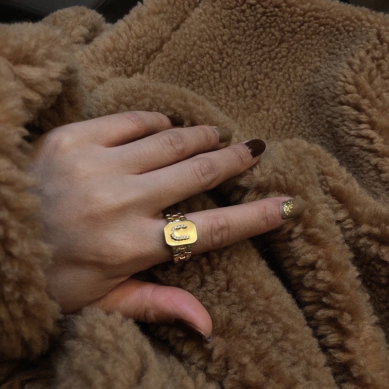 A model wearing a thick gold ring.