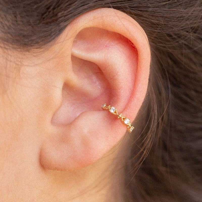 A model wearing a single gold Crystal Celestial Ear Cuff.