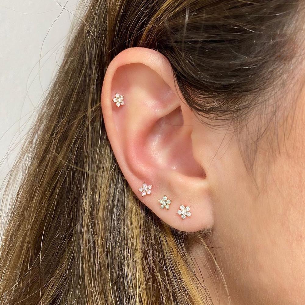 A model wearing four CZ Flower Stud earrings.