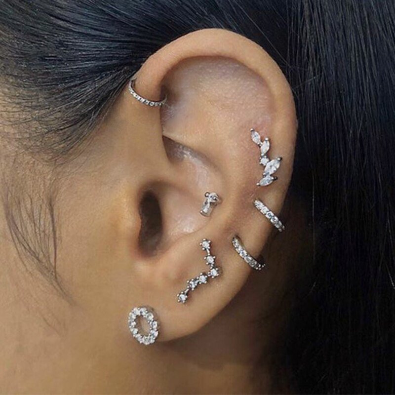 A model wearing multiple silver CZ hoop and cartilage piercings.