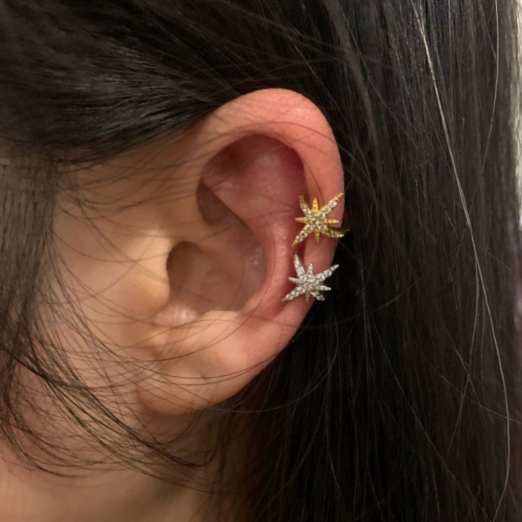 A woman wearing a silver and gold Dazzling Star Ear Cuff.