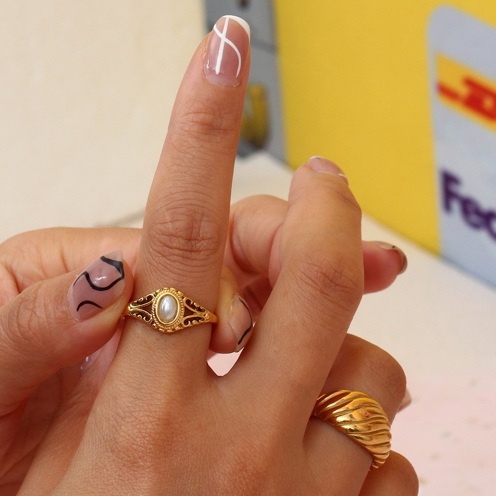 A model wearing a gold pearl ring.