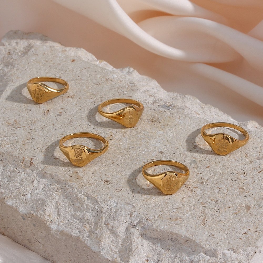 Five gold oval signet rings on a stone.