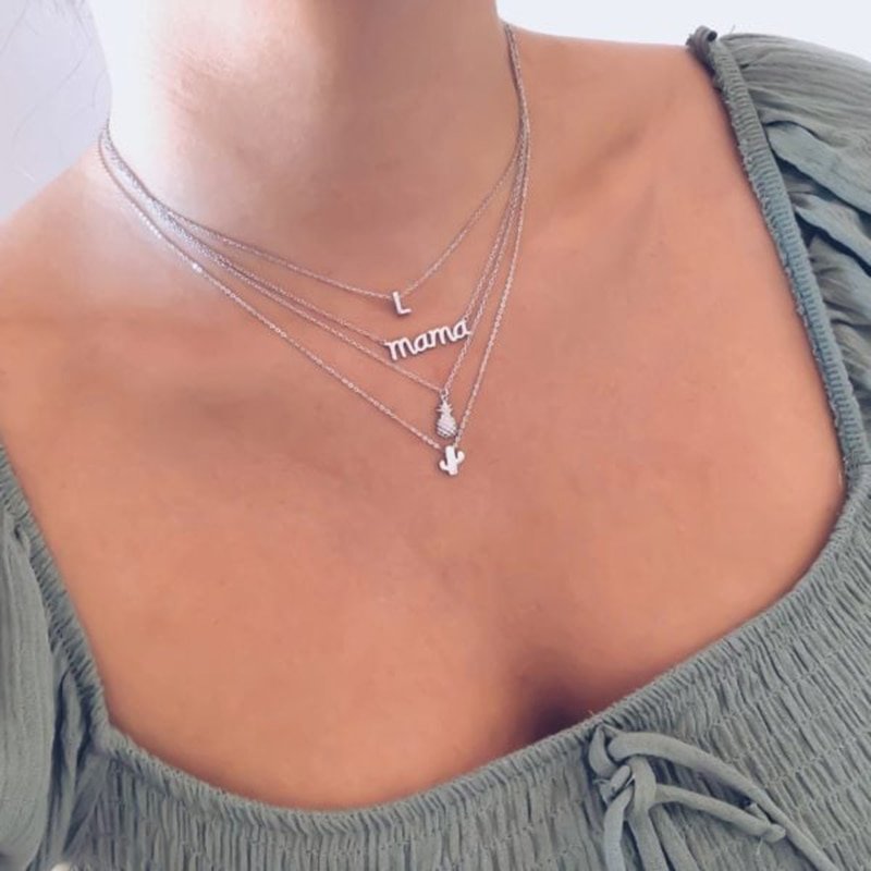 A model wearing multiple silver layering necklaces.
