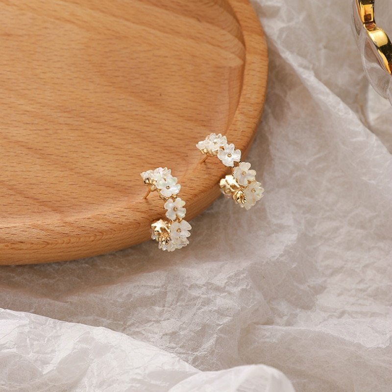 Gold hoops with iridescent resin flowers.