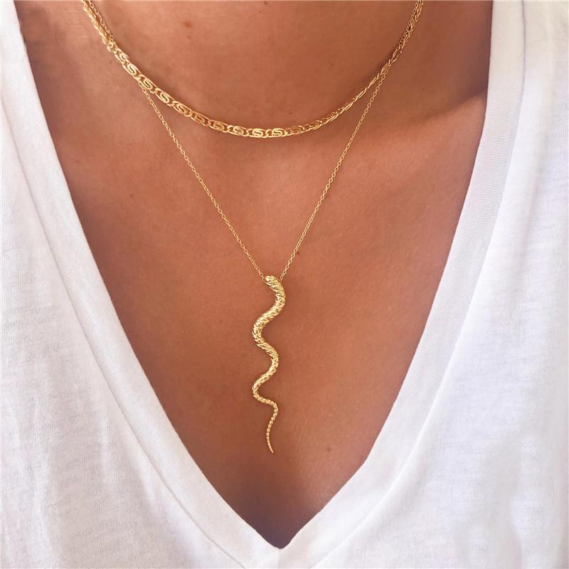A model wearing a gold serpent necklace.