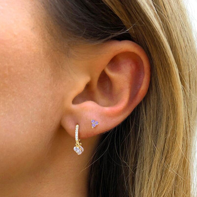 A model wearing tiny stud earrings.