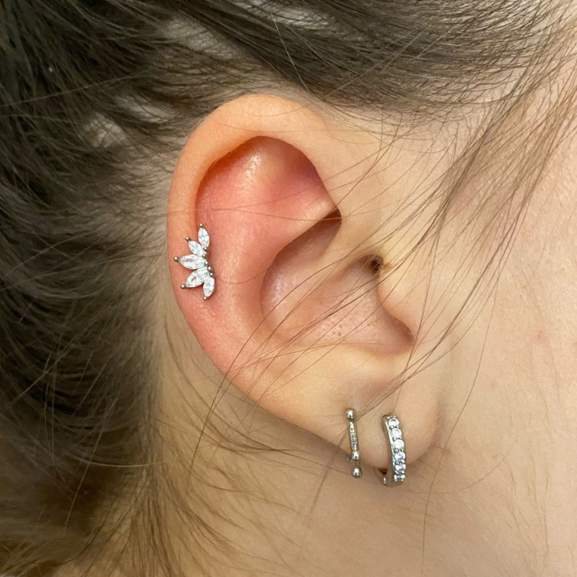 A woman wearing the Marquise Crown Cartilage Stud in silver.