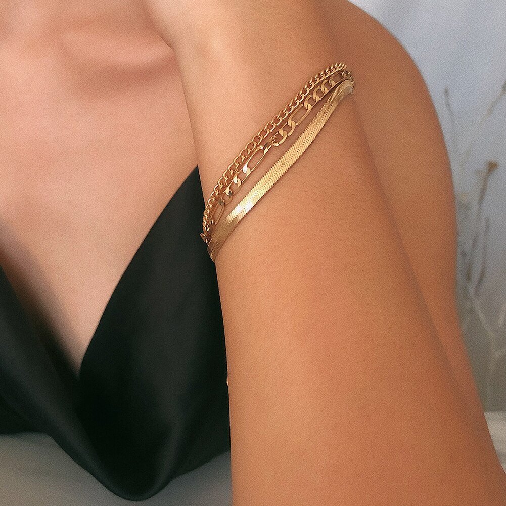 A woman wearing multiple gold bracelets.