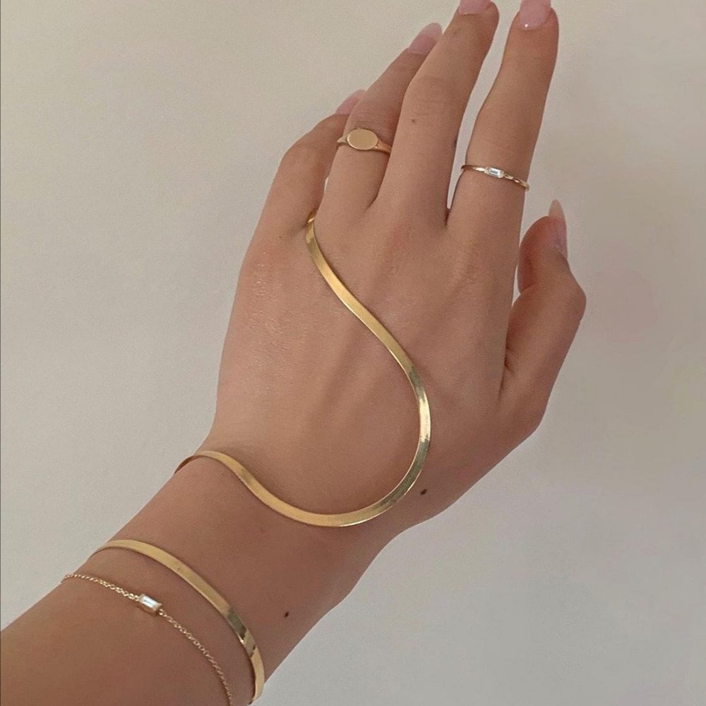 A model wearing gold bracelets and rings.