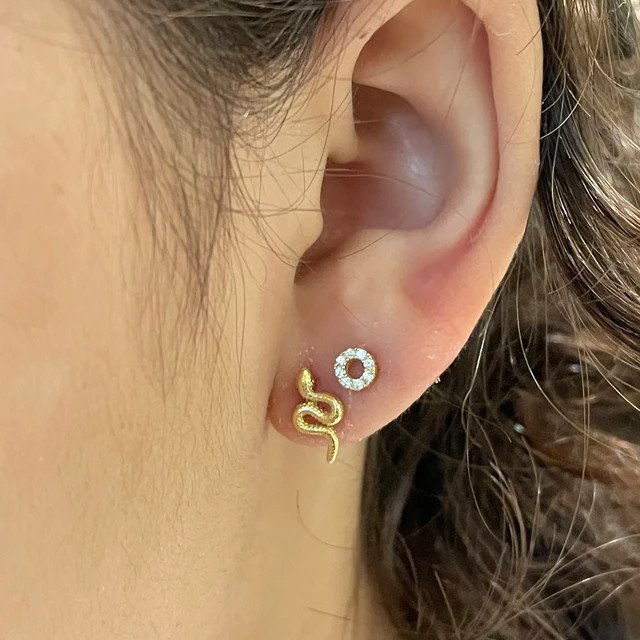 A woman wearing the Snake Slither Earrings.