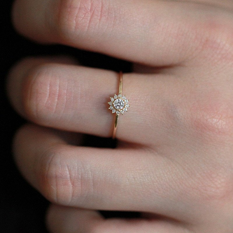 A model wearing a gold CZ halo ring.