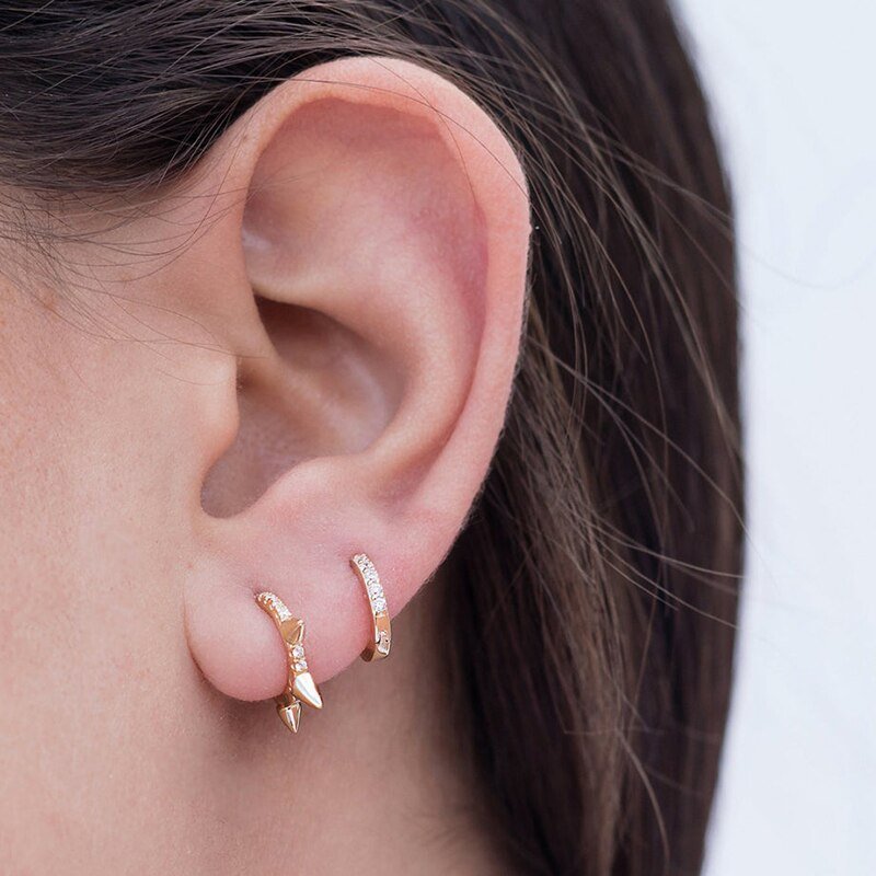 A model wearing edgy spike earrings.