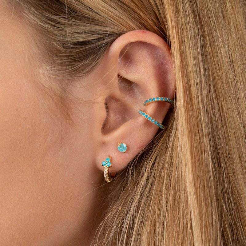 A model wearing the Turquoise Trinity CZ Huggies.