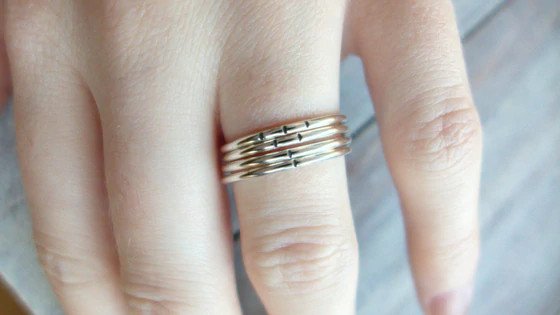 A woman wearing silver stacking rings.