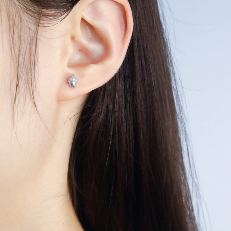 A model wearing the silver Acorn CZ Studs.