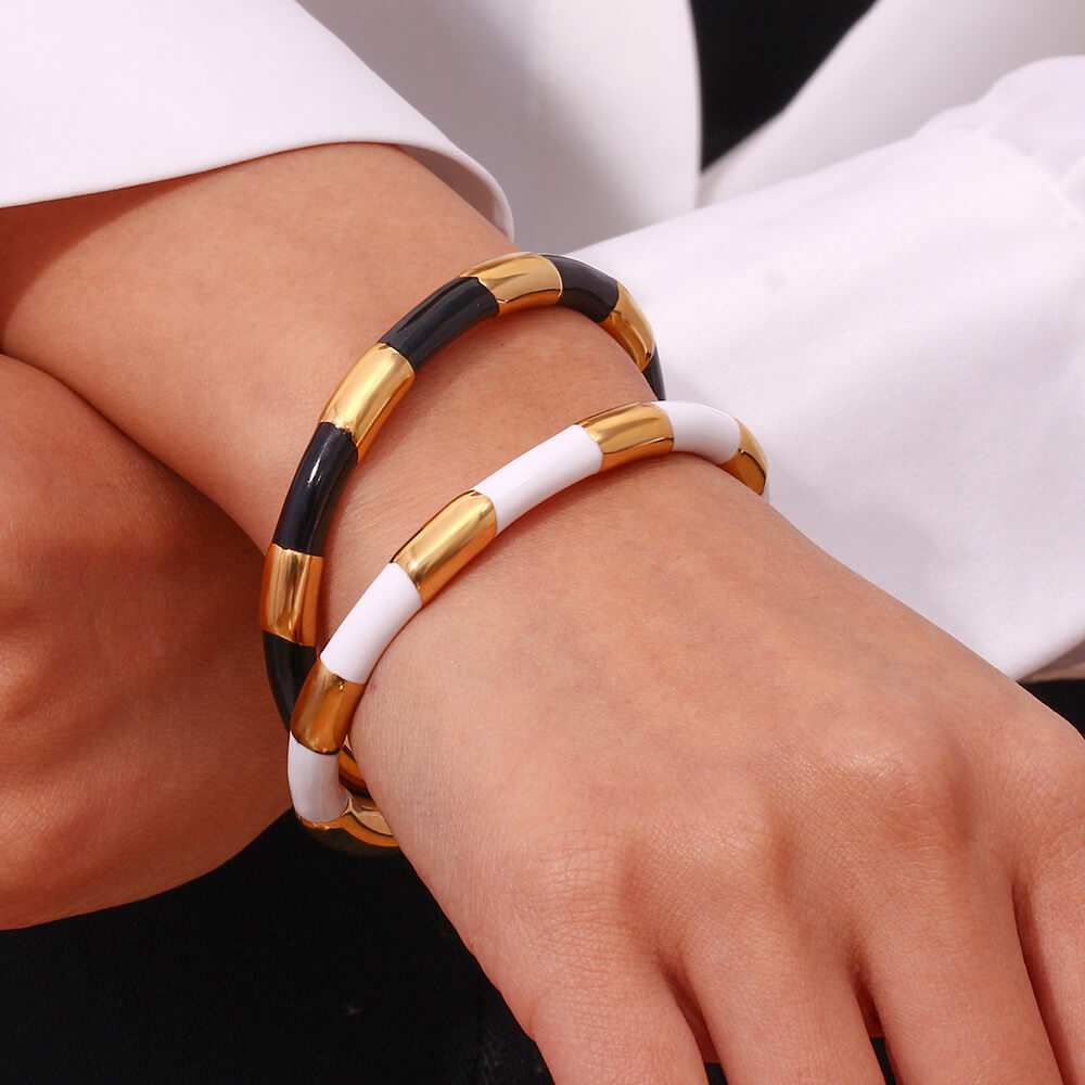 A woman wearing the Black Enamel Gold Bangle.