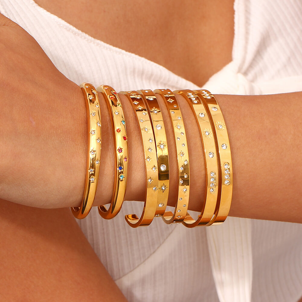 A woman wearing multiple gold stacking bracelets.