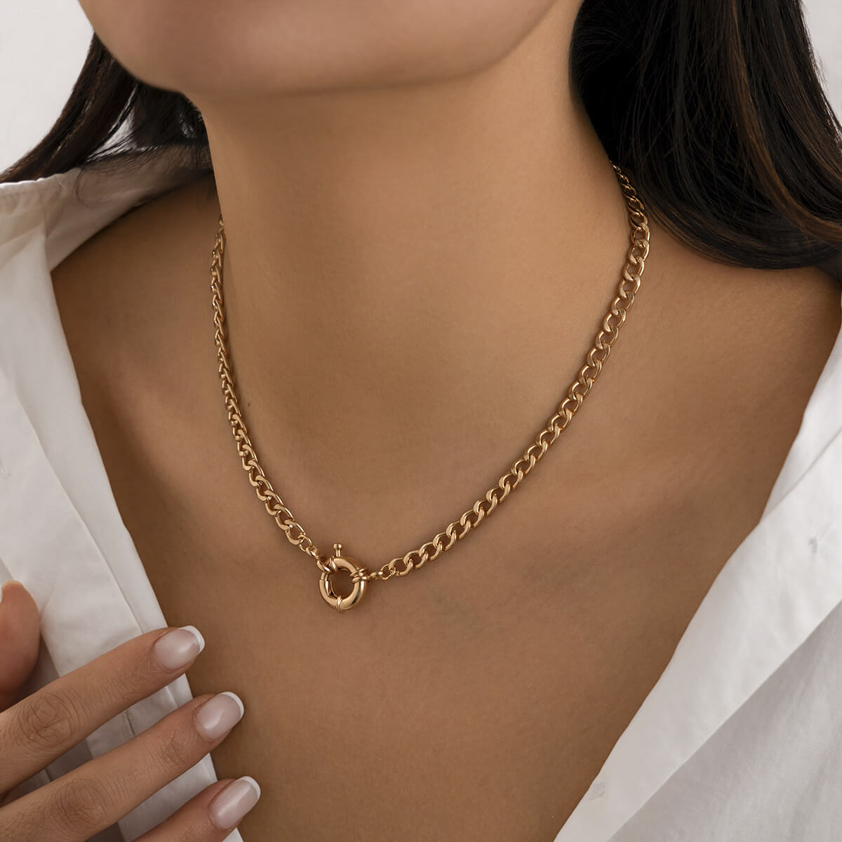 A woman wearing a curb chain gold necklace.