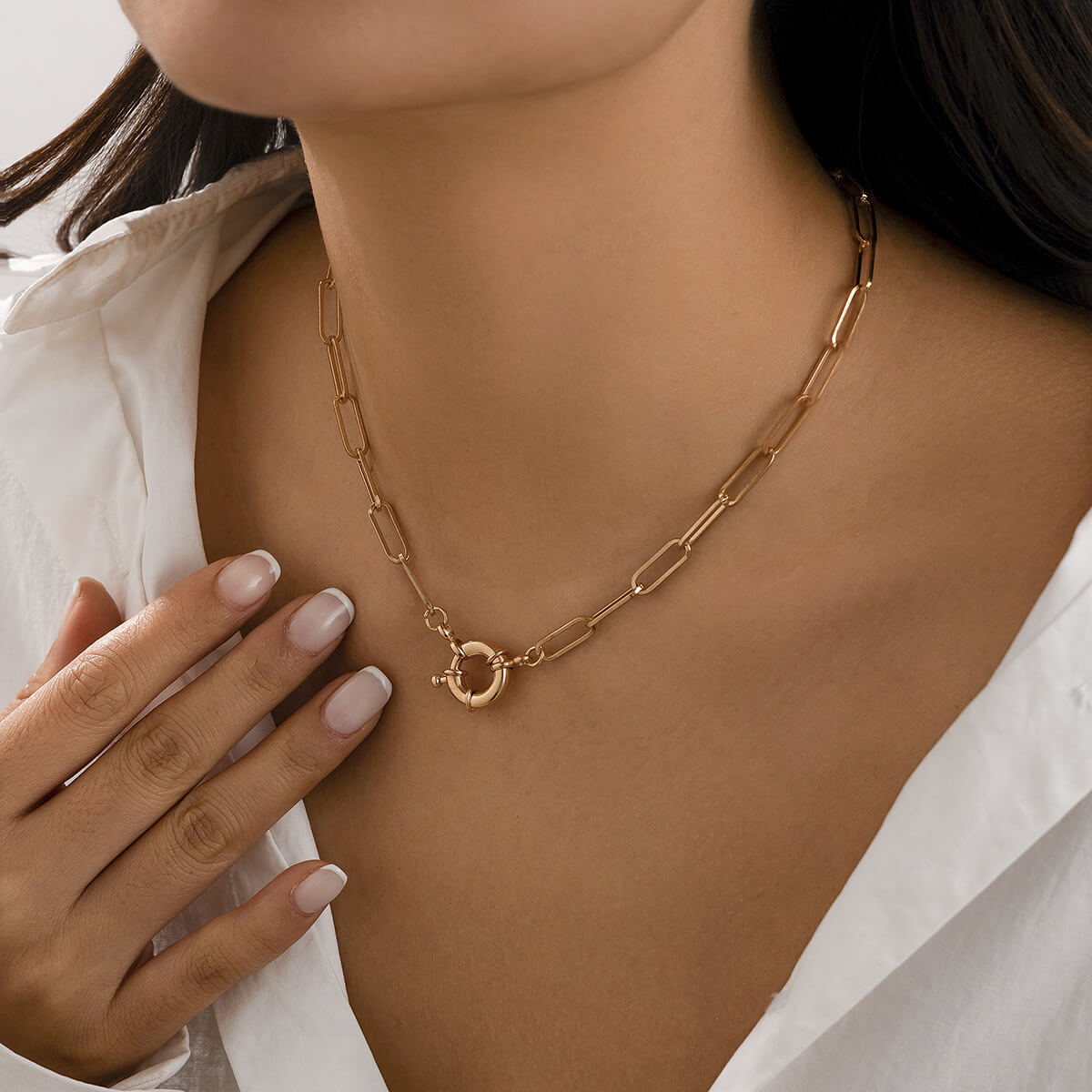 A woman wearing a front clasp chain necklace.