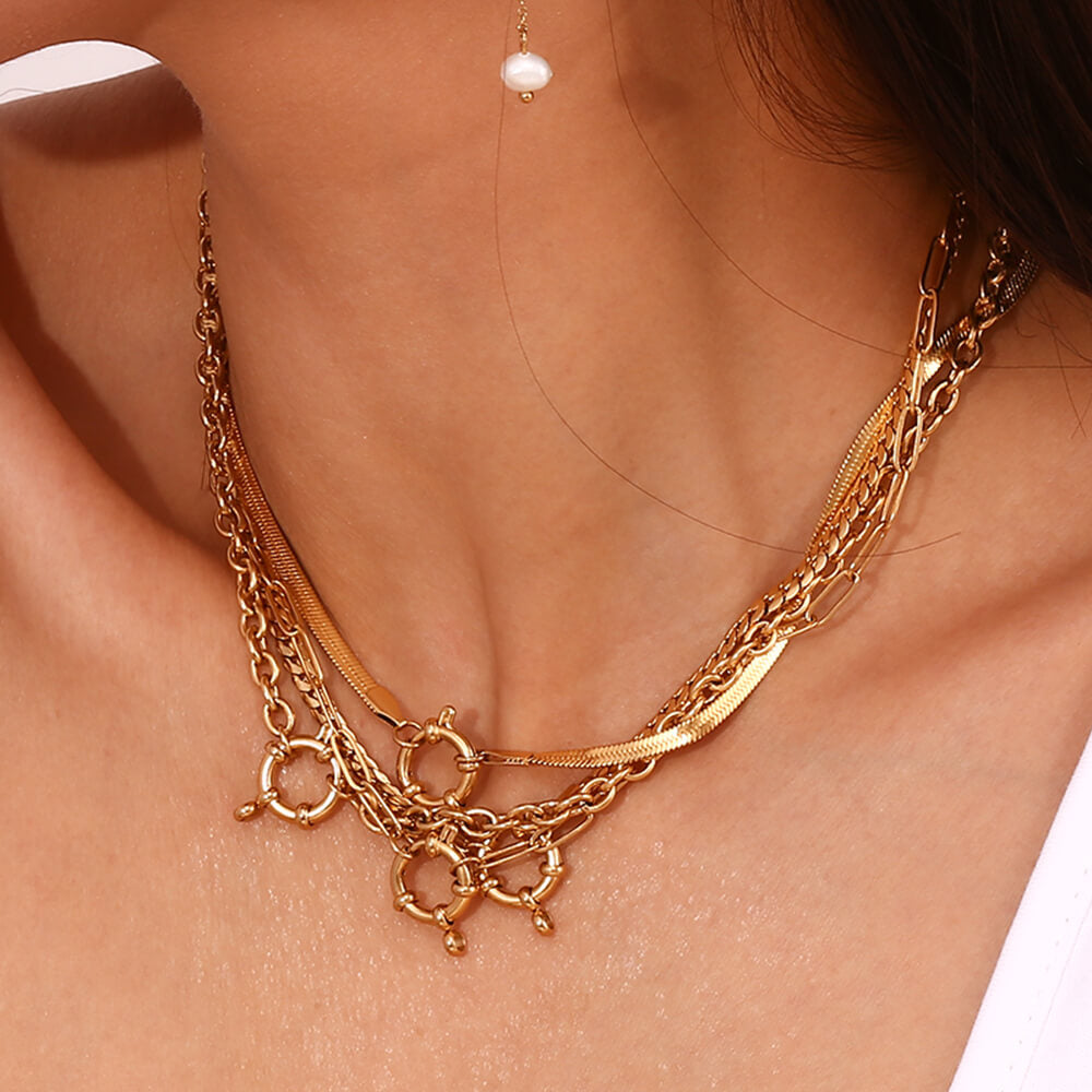 A woman wearing lots of gold layering necklaces.