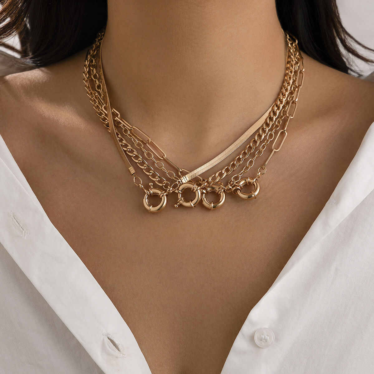 A model wearing multiple gold necklaces.