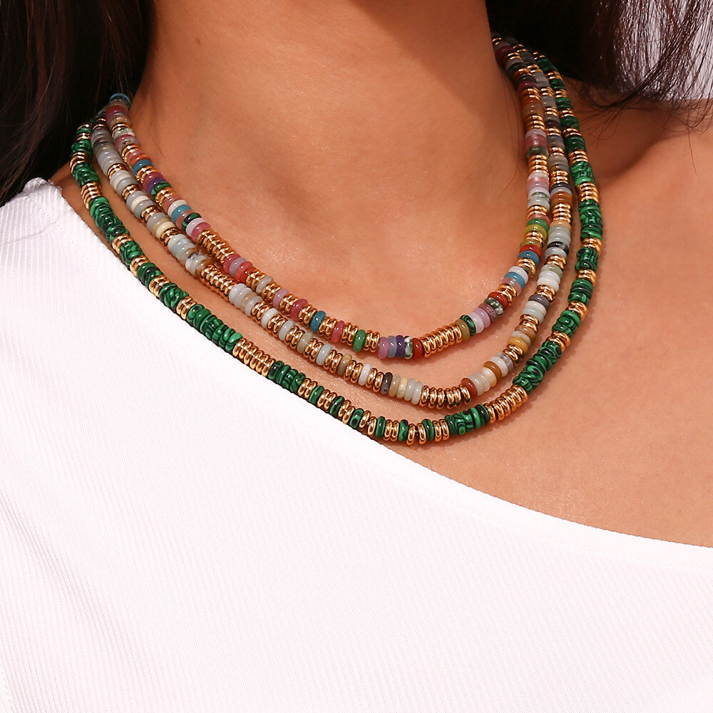 A woman wearing multiple Gemstone Rondelle Beaded Gold Necklaces.