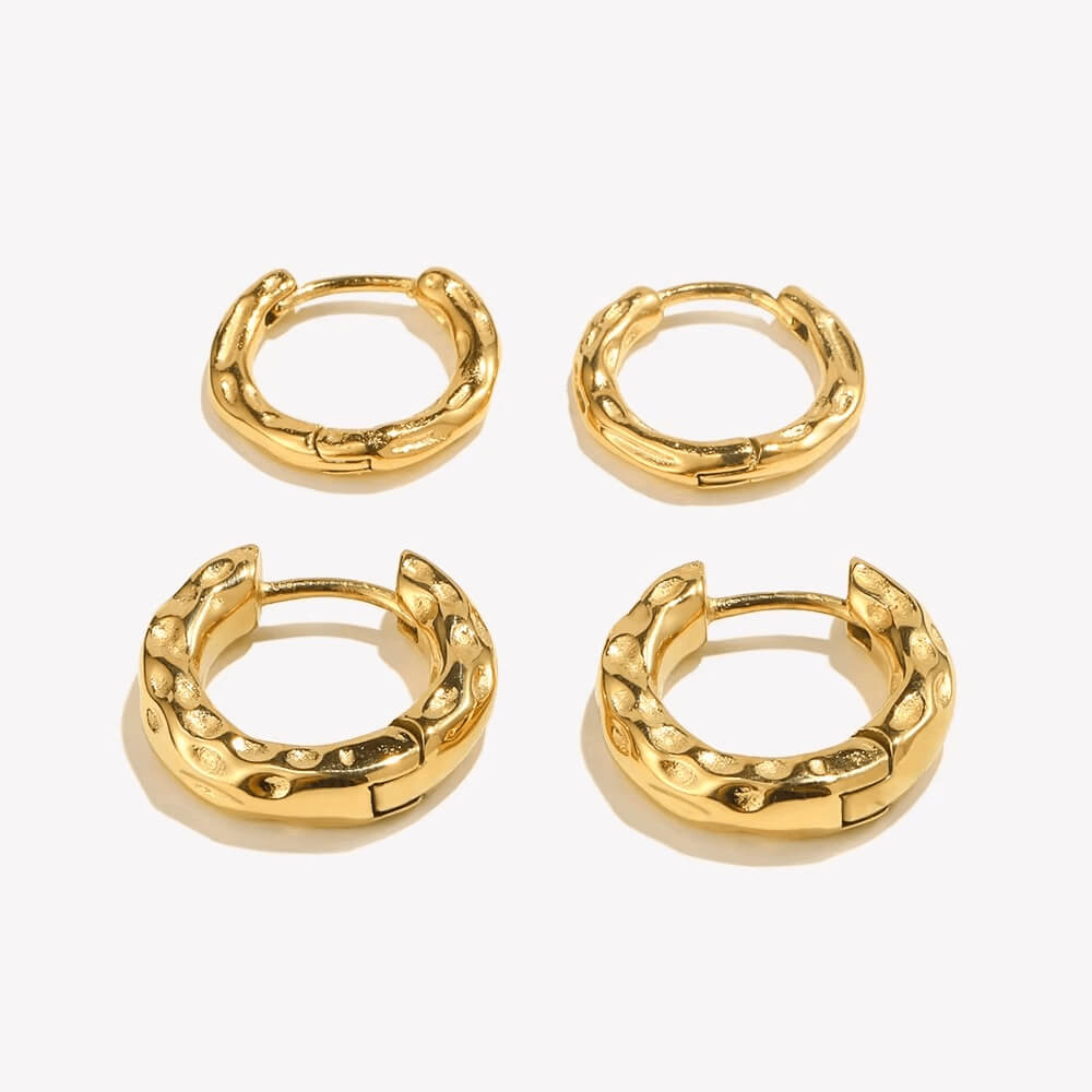 Four gold hoop earrings on a white background.