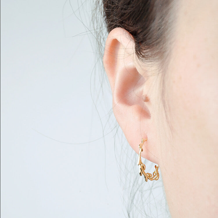 Branch hoop earrings worn by a model.