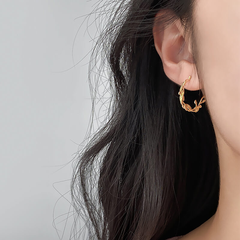 A model wearing the gold Mistletoe Hoops.