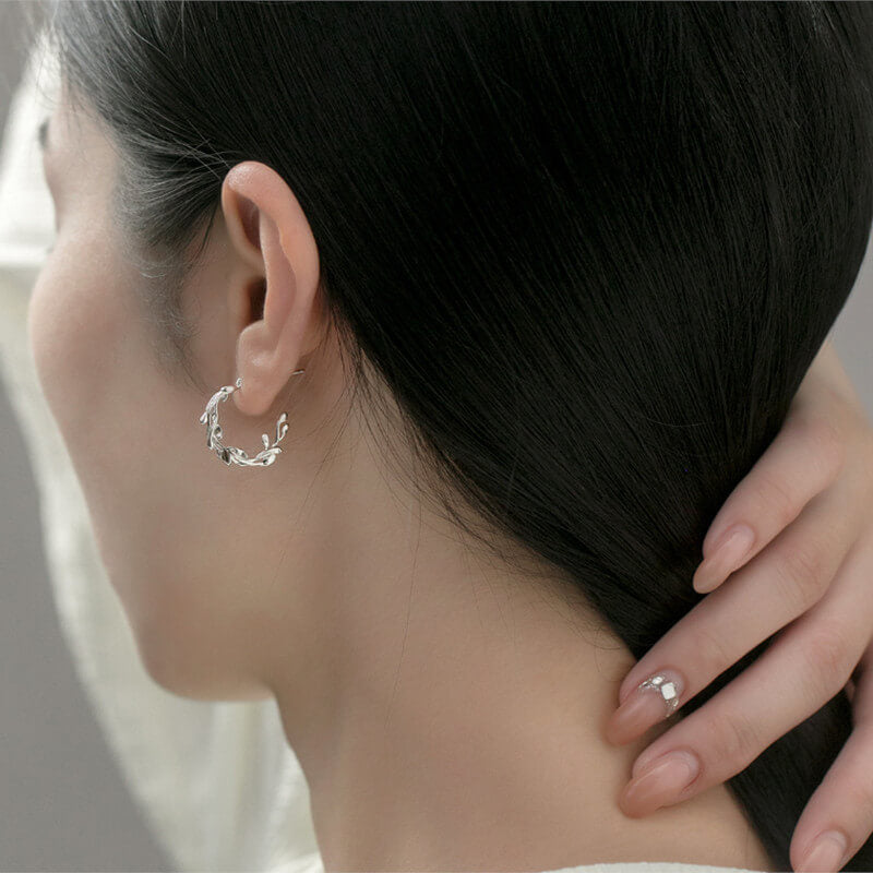 A woman wearing the silver Mistletoe Hoops.