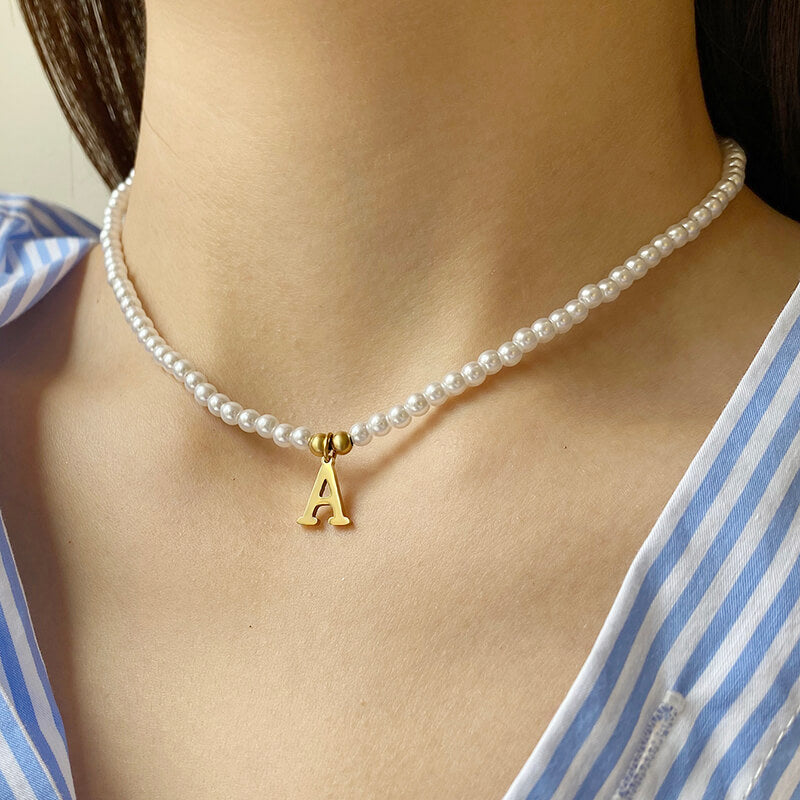 A woman wearing the Pearl Initial Gold Necklace.