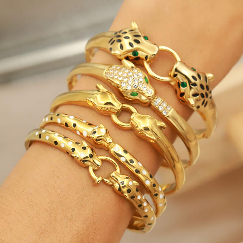 A model wearing multiple gold leopard bangles.