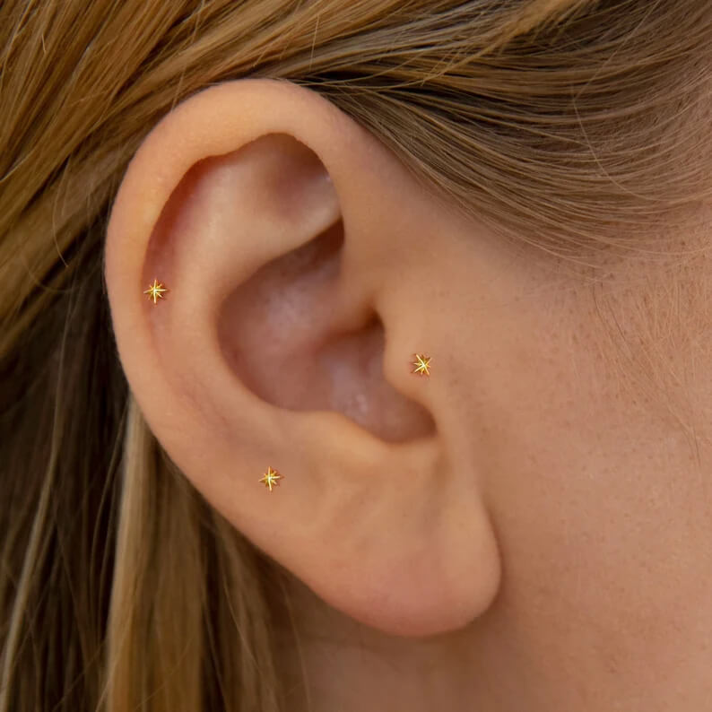 A model wearing the Tiny Gold Star Studs.