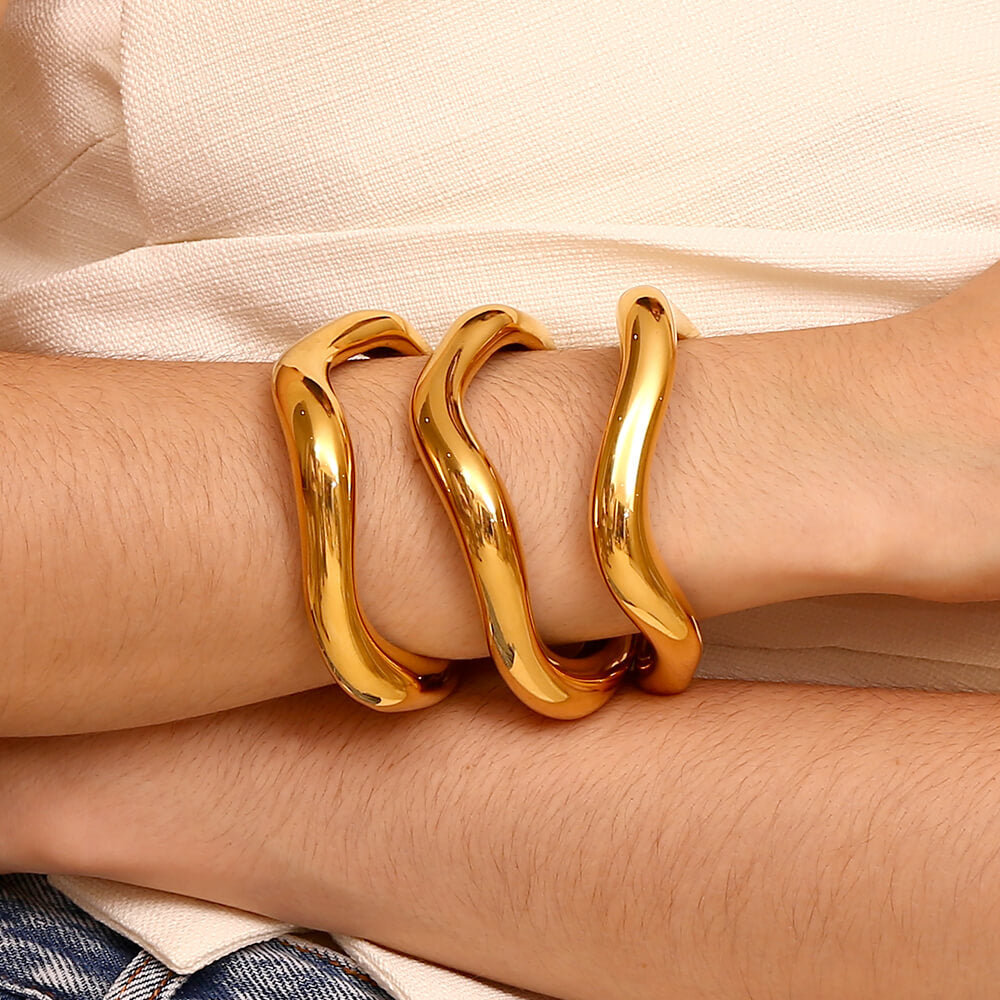 A woman wearing multiple Wavey Chunky Bangles.