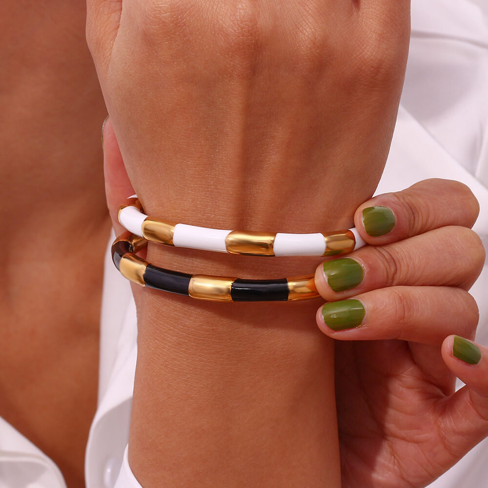 A woman wearing the White Enamel Gold Bangle.